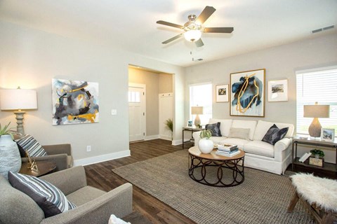 a living room with furniture and a ceiling fan